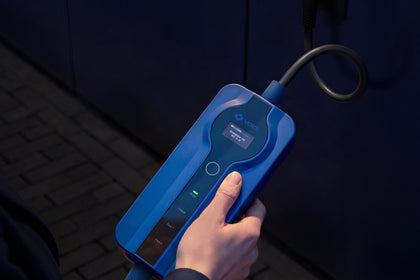 Hand holding the control box of the Voldt® Type 1 Portable Charger at night